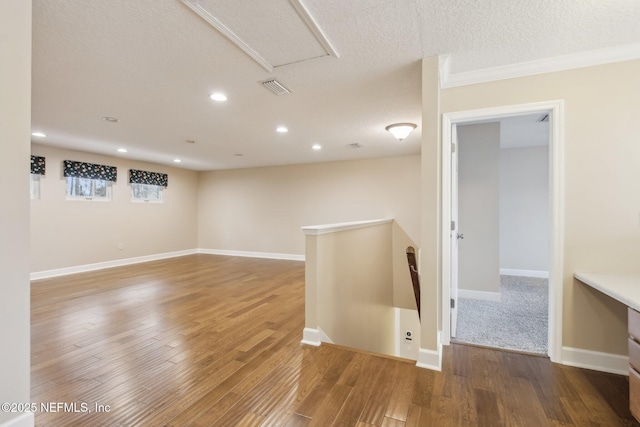 spare room featuring wood-type flooring and a textured ceiling