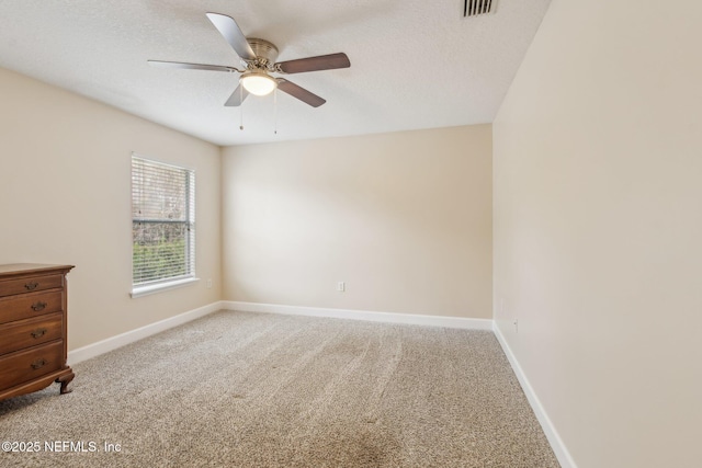 carpeted empty room with ceiling fan and a textured ceiling