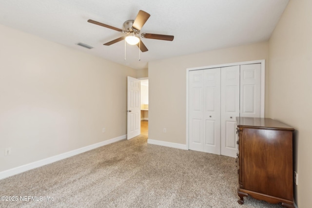 unfurnished bedroom with ceiling fan, light colored carpet, and a closet