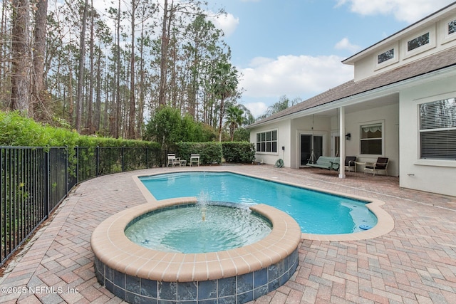 view of swimming pool with a patio area and an in ground hot tub