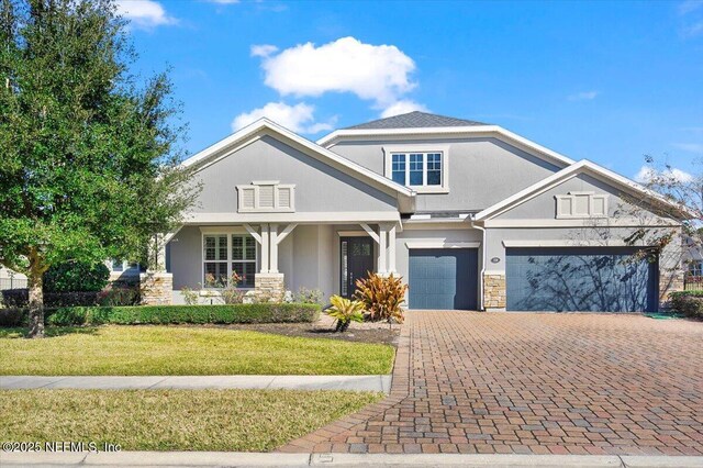 craftsman inspired home with a garage and a front yard