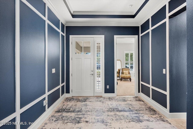 carpeted entryway with crown molding and a raised ceiling