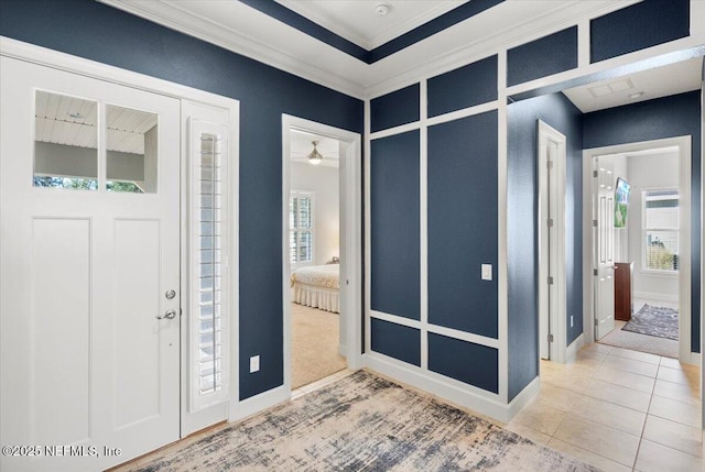 foyer featuring tile patterned flooring and crown molding