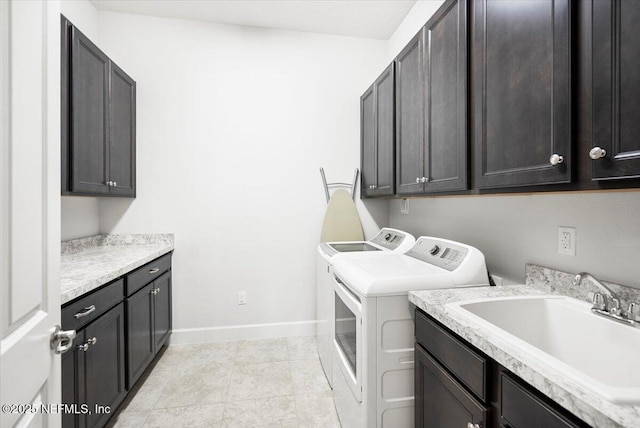 laundry room with independent washer and dryer, sink, cabinets, and light tile patterned floors