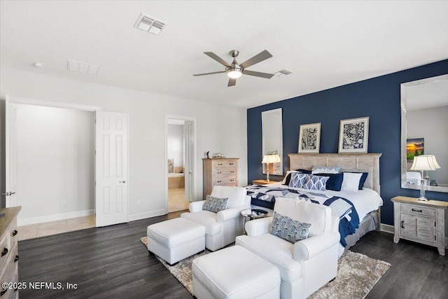 bedroom with ceiling fan, connected bathroom, and dark hardwood / wood-style flooring