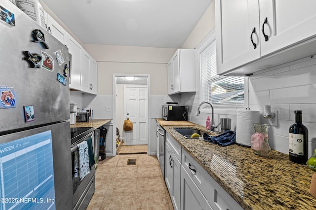 kitchen with white cabinetry, appliances with stainless steel finishes, sink, and stone counters