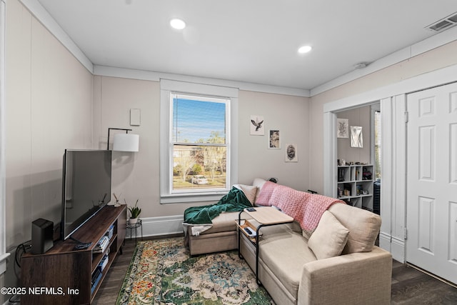 living room featuring dark wood-type flooring and ornamental molding