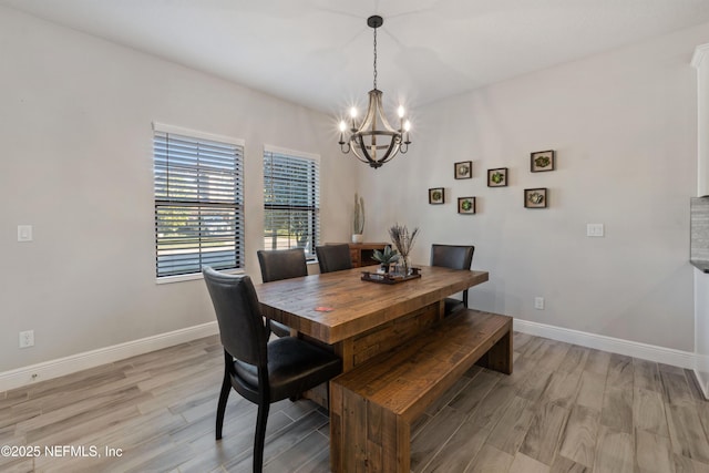 dining area with a notable chandelier and light hardwood / wood-style floors