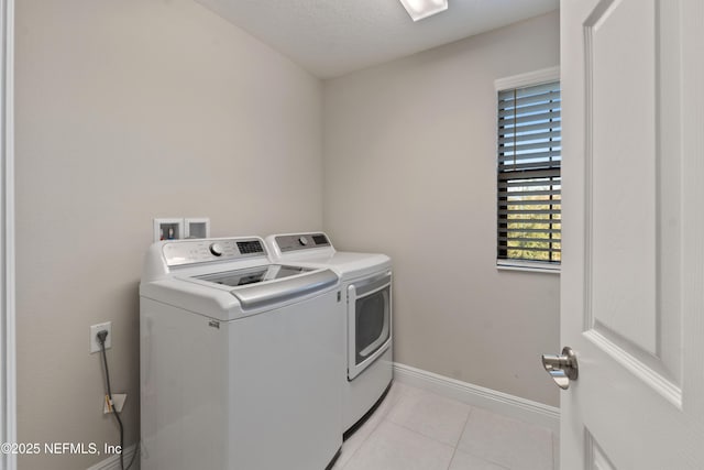 laundry room with washing machine and clothes dryer and light tile patterned floors