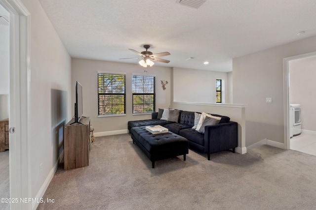 carpeted living room featuring ceiling fan and a textured ceiling