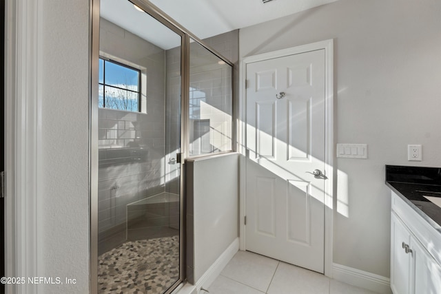 bathroom with vanity, a shower with shower door, and tile patterned flooring