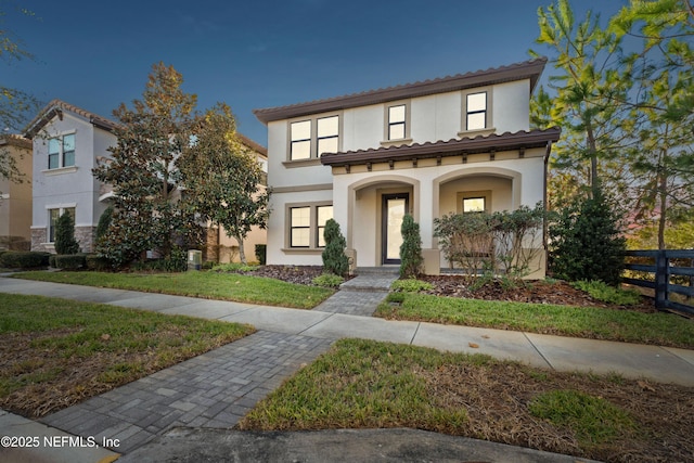 mediterranean / spanish-style home featuring a porch and a front yard