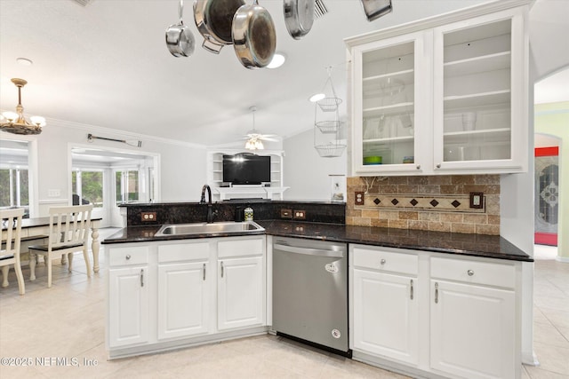 kitchen featuring tasteful backsplash, dark stone counters, glass insert cabinets, stainless steel dishwasher, and a sink