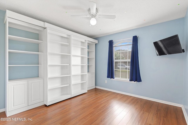 unfurnished bedroom featuring a ceiling fan, baseboards, and wood finished floors