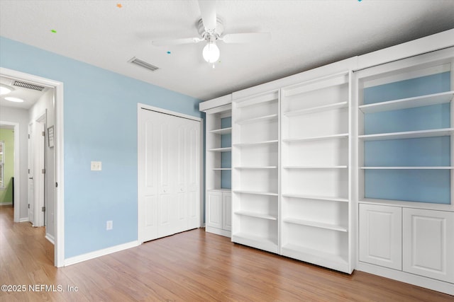 unfurnished bedroom featuring visible vents, baseboards, and wood finished floors