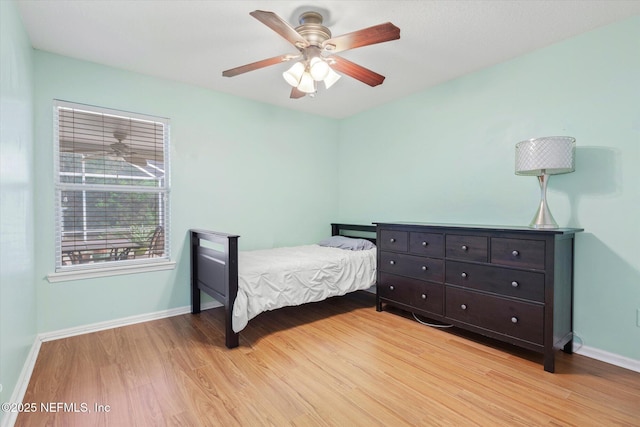 bedroom with light wood-style floors, ceiling fan, and baseboards