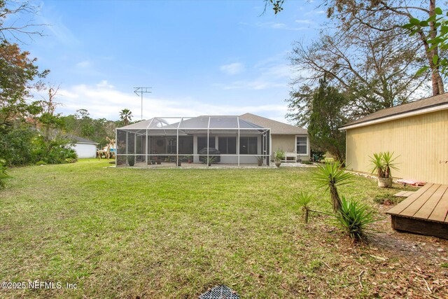 rear view of house featuring a lanai and a yard