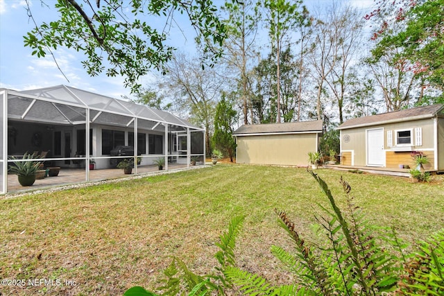 view of yard featuring glass enclosure, a patio, and an outdoor structure