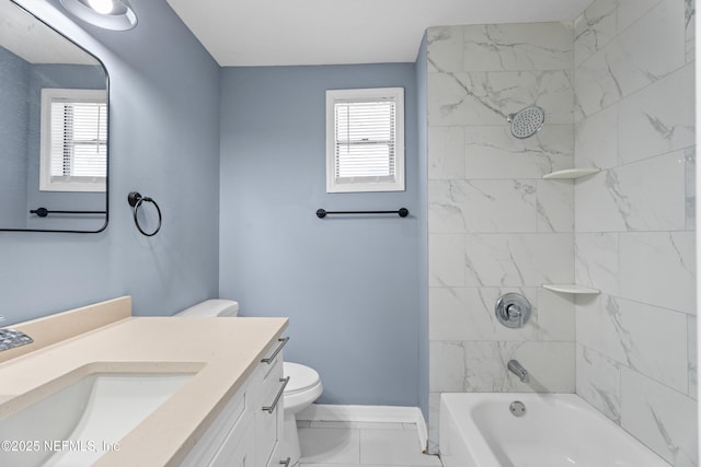 full bathroom featuring tiled shower / bath, vanity, and toilet