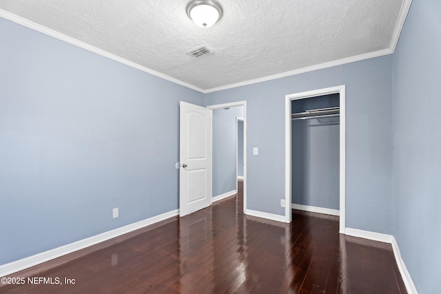 unfurnished bedroom featuring dark hardwood / wood-style flooring, crown molding, a closet, and a textured ceiling