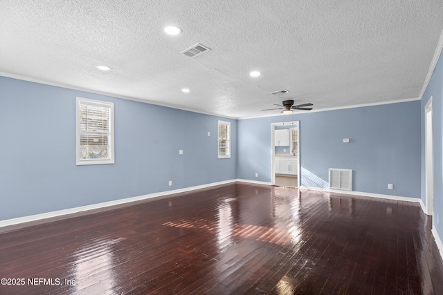 empty room featuring wood-type flooring, a wealth of natural light, and crown molding