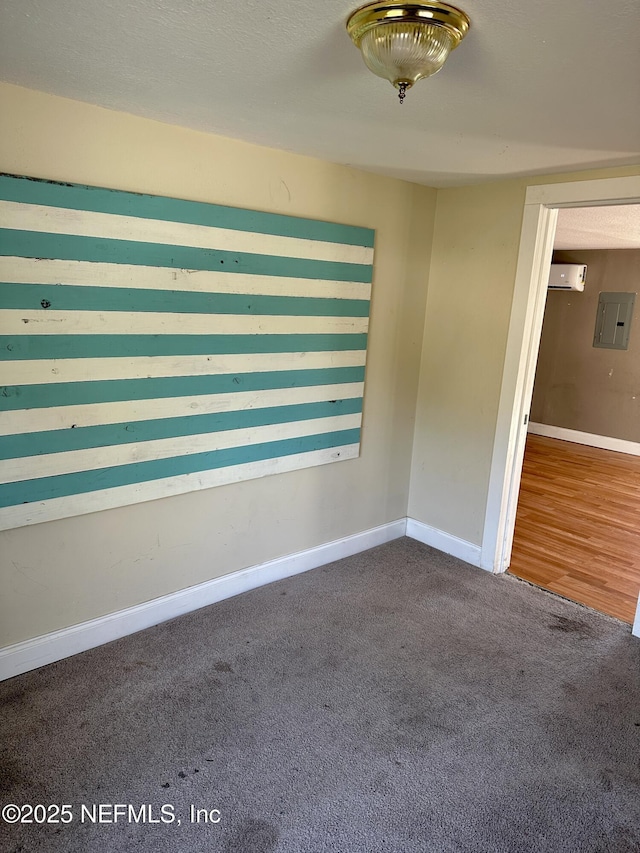 carpeted empty room with electric panel and a wall mounted AC