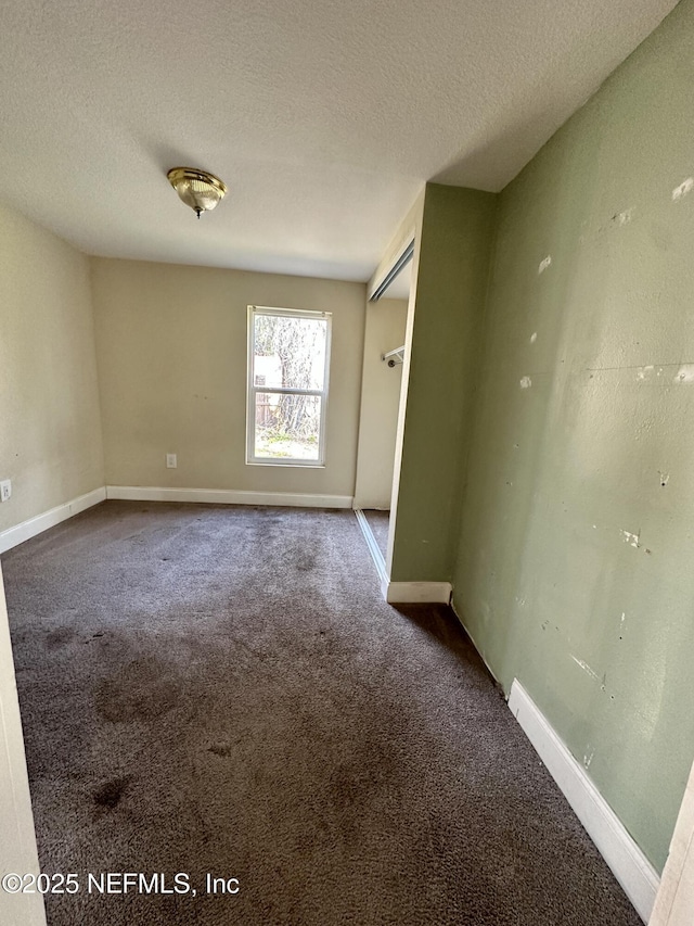 spare room featuring carpet and a textured ceiling