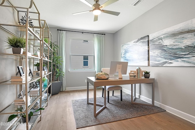 office with light hardwood / wood-style floors and ceiling fan