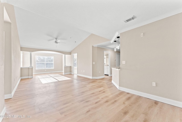 unfurnished living room featuring lofted ceiling, ornate columns, light wood-type flooring, ornamental molding, and ceiling fan