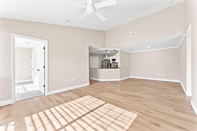 unfurnished living room with ceiling fan, lofted ceiling, and light wood-type flooring