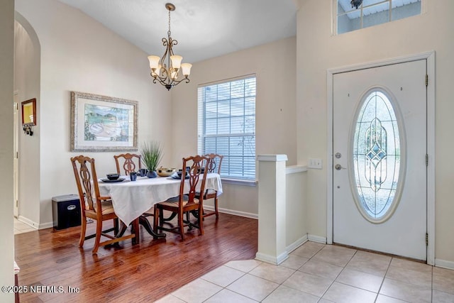 tiled foyer entrance featuring an inviting chandelier and plenty of natural light