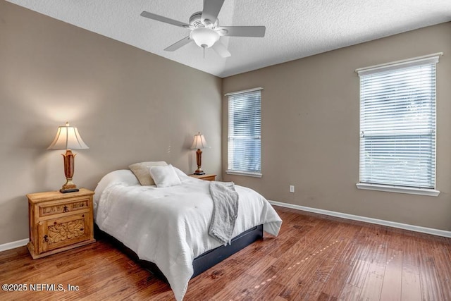 bedroom with multiple windows, a textured ceiling, and ceiling fan