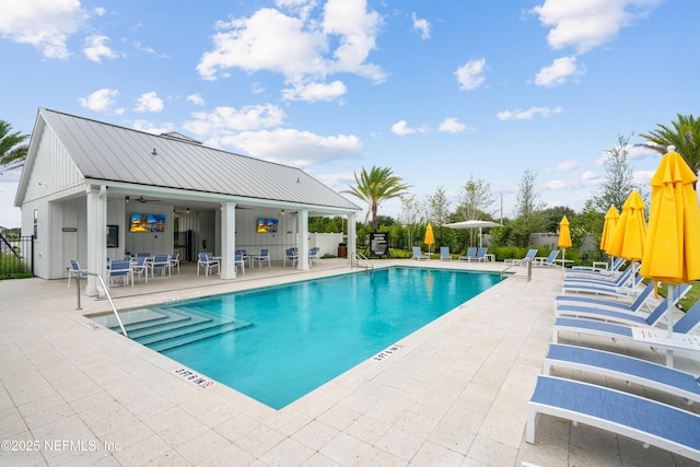 view of swimming pool featuring ceiling fan and a patio area