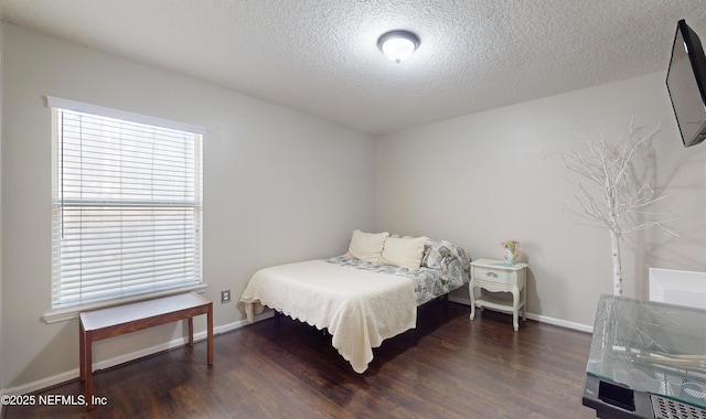 bedroom featuring dark wood-type flooring and a textured ceiling