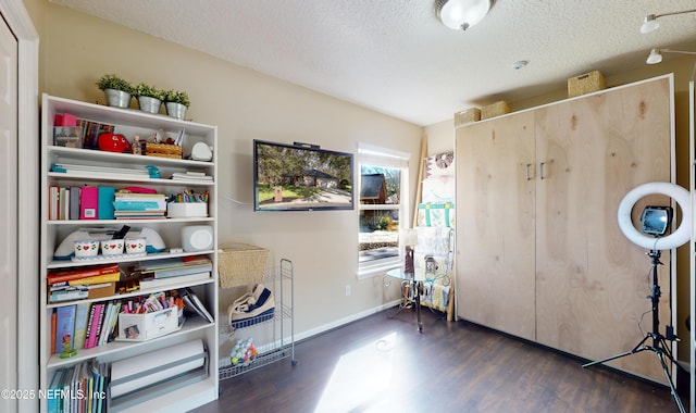 misc room with a textured ceiling and dark hardwood / wood-style flooring