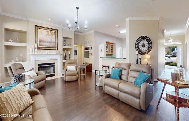 living room featuring crown molding, a textured ceiling, dark hardwood / wood-style flooring, and built in shelves