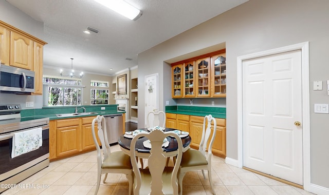 kitchen featuring pendant lighting, light tile patterned floors, sink, and appliances with stainless steel finishes