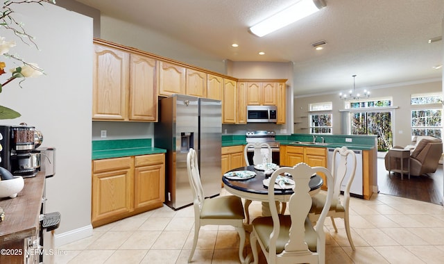 kitchen featuring stainless steel appliances, decorative light fixtures, a chandelier, and light tile patterned floors