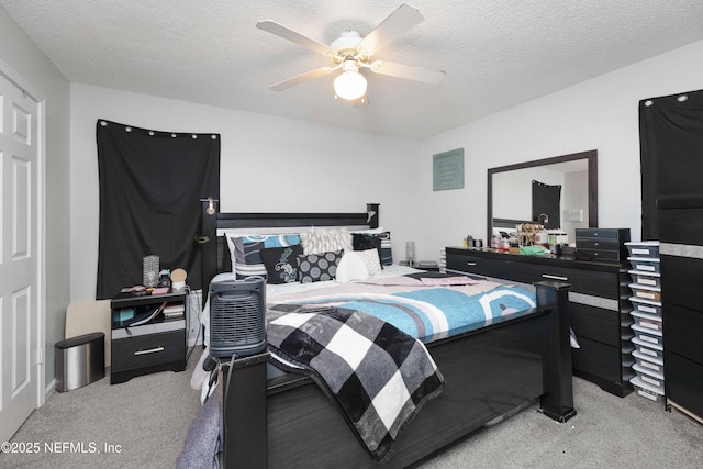 carpeted bedroom with ceiling fan and a textured ceiling