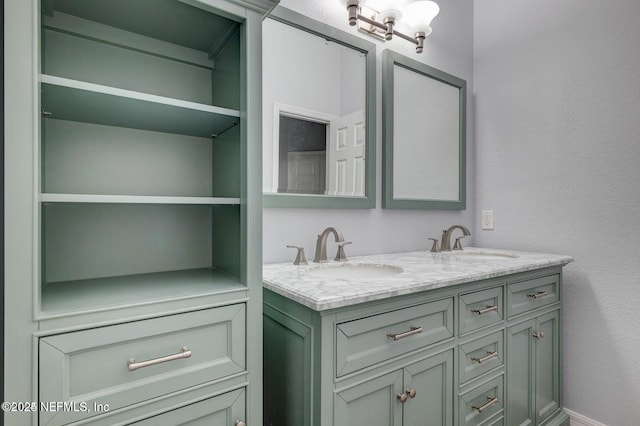 bathroom with a textured wall, double vanity, and a sink