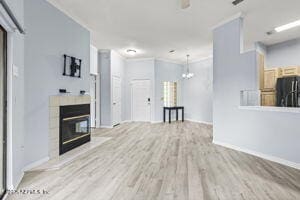 unfurnished living room featuring wood finished floors and a glass covered fireplace