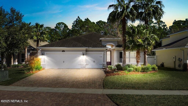 view of front of property with a garage and a yard