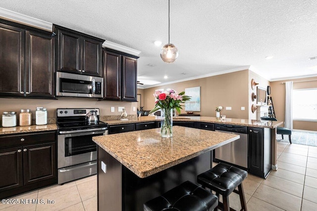 kitchen featuring pendant lighting, a breakfast bar area, appliances with stainless steel finishes, a center island, and kitchen peninsula