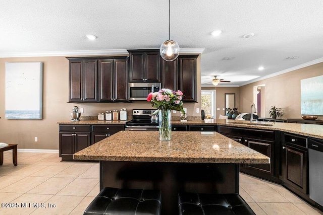 kitchen featuring sink, dark brown cabinets, a breakfast bar area, and appliances with stainless steel finishes