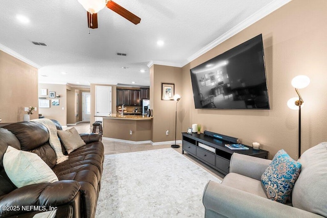 tiled living room featuring ceiling fan, ornamental molding, and a textured ceiling