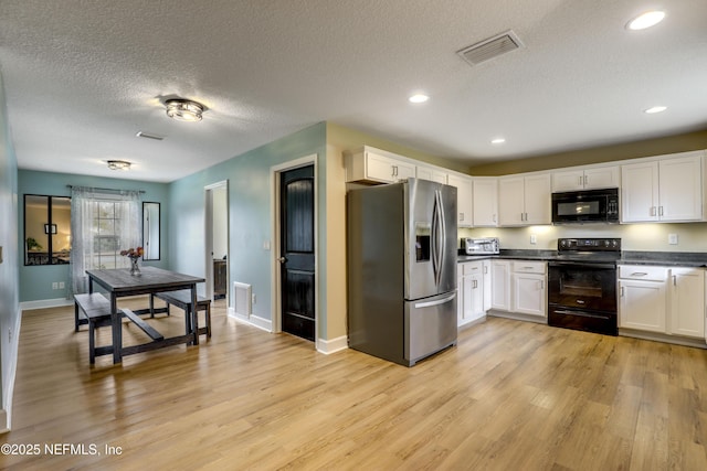 54110 Marlee Rd, Callahan, FL 32011 - kitchen featuring white cabinetry, light hardwood / wood-style floors, a textured ceiling, and black appliances