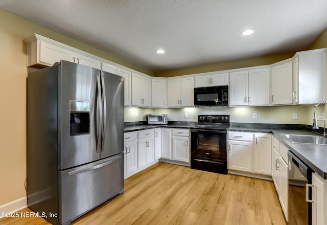 54110 Marlee Rd, Callahan, FL 32011 - kitchen with sink, white cabinets, black appliances, a textured ceiling, and light hardwood / wood-style flooring