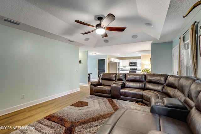 54110 Marlee Rd, Callahan, FL 32011 - living room with a raised ceiling, ceiling fan, a textured ceiling, and light wood-type flooring