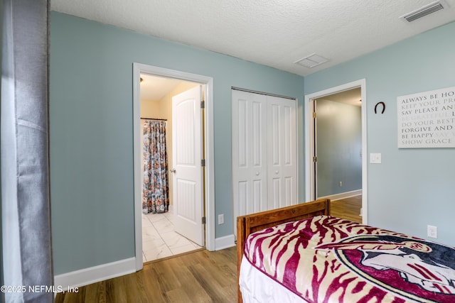 54110 Marlee Rd, Callahan, FL 32011 - bedroom featuring hardwood / wood-style flooring, ensuite bathroom, a textured ceiling, and a closet