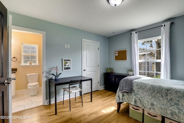 54110 Marlee Rd, Callahan, FL 32011 - bedroom featuring light wood-type flooring, a textured ceiling, and ensuite bath